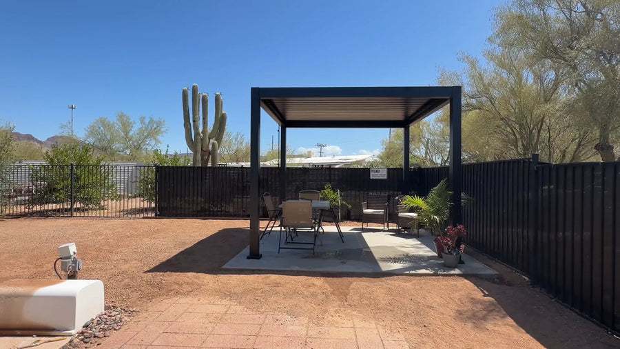Black aluminum louvered pergola providing shade over a sunny backyard patio